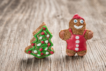 Gingerman and Christmas tree cookies on wooden baclkground