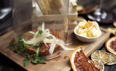 tartar beefsteak under glass bell on plate