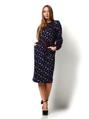 Young happy beautiful woman posing in new fashion blue winter dress