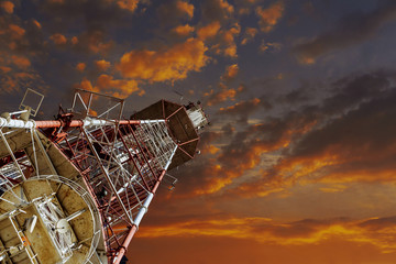 Telecommunications tower against blue sky, in red and white