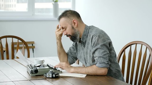 Male writer looking for inspiration and typiing on the typewriter