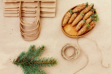 Christmas handmade gifts and everything you need for them. Bags from Kraft paper, fir branches and jute cord. Top view, the concept of simplicity and minimalism