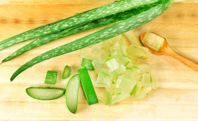 the sliced and leaf of fresh aloe vera on  wooden plate , natural clear gel as the star beauty ingredient  for skin care