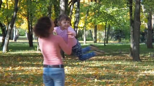Mother circling child in the park. Emotions of a happy little girl.