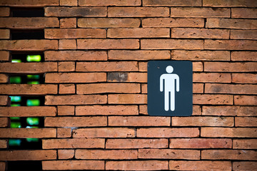 Toilet sign in a brick wall