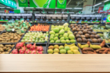 Empty wooden table and supermarket blurred fruits background