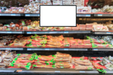 Blank supermarket TV screen and blurred supermarket ham sausage background