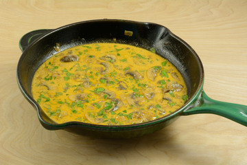 Homemade cream mushroom sauce in cast iron frying pan skillet