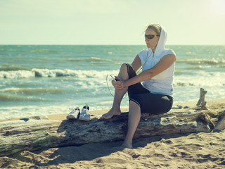 Woman during a pause between sessions with fitness by the sea.