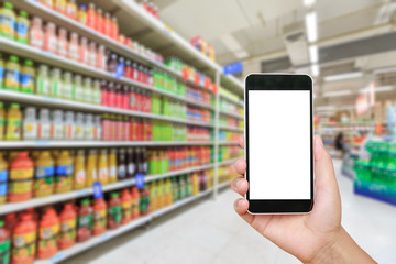 Hand holding smartphone with white blank screen and blurred supermarket drink background