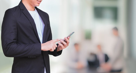 Businessman using smart phone in blurred office space background and copy space.Concept of business people use technology.