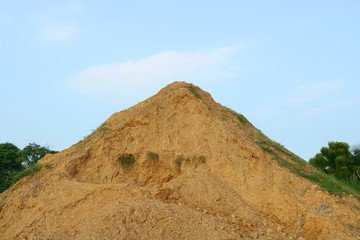 Piles of sand and stone on blue sky background.