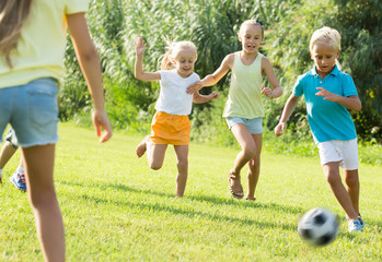 children playing football on meadow .