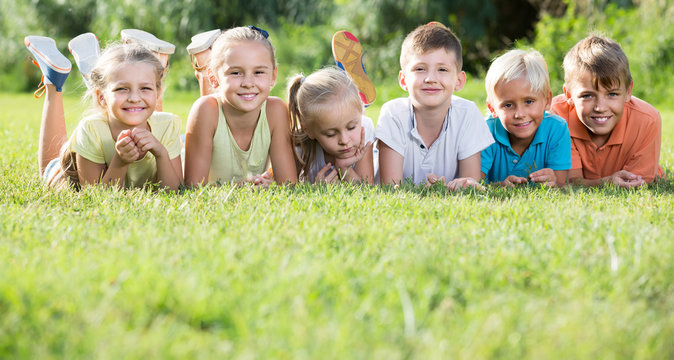 portrait of  children lying on grass in park and looking happy