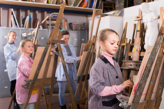 schoolgirls diligently training their painting skills during class at art studio