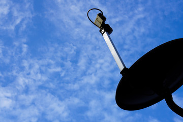 satellite dish on roof and cloudy blue sky  