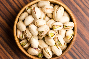 Salted Pistachio nuts in wooden bowl