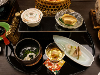 Japanese ryokan kaiseki dinner appetizer including cherry blossom tofu, lily bulb tofu, horse tail, silvervine and sesame, monkfish liver mousse, other side dishes and plum liquor