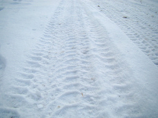 Traces of wheels on snow background
