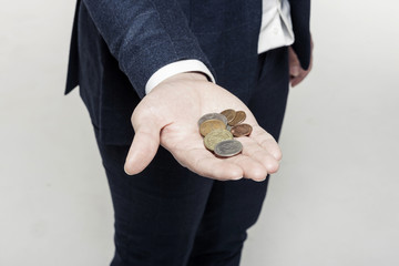 asian man hand hold a coin with pig coin bank isolated white. 