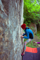 Naklejka na ściany i meble Climber is bouldering outdoors.