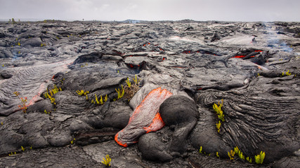 Lava destroys a landscape under cloudy skies