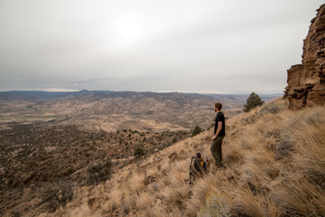 Tall young man on mountainside while Backpacking near the Painted Hills