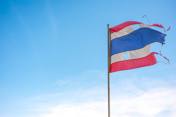 thailand torn flag with blue sky  and wind