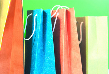 Concept of shopping. Colorful shopping bags arranged on a green background.