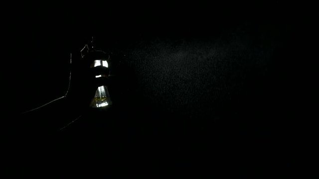 Close-up silhouette of a girl spraying perfume in the dark, slow motion.