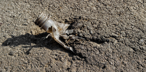Poor quality asphalt. Bottle rolled in asphalt. Asphalt background