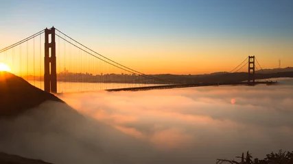 Foto op Plexiglas Golden Gate Bridge Spectaculaire zonsopgang bij Golden Gate Bridge met lage mist.