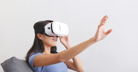 Woman watching with VR device on sofa © leungchopan