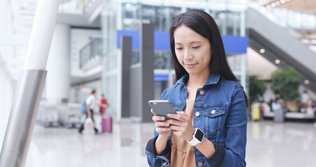 Woman using cellphone in airport