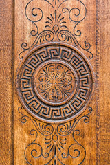 Embossed round ornament on a brown wooden surface