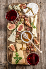 Cheese plate served with wine, nuts and honey 