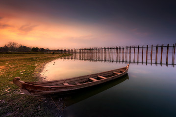 Sunset in U Bein bridge with vintage boat, Myanmar
