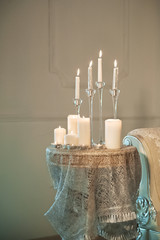 Many lit candles stand on the table. Background for your text.