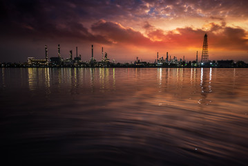 Fototapeta premium Oil and gas industry - refinery at Sunrise - factory - petrochemical plant with reflection over the river