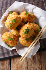 Japanese fried hot potato korokke or croquettes in breading close-up on the table. Vertical top view