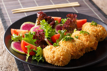 Potato croquettes, or Japanese Korokke, served with fresh salad close-up on a plate. horizontal.