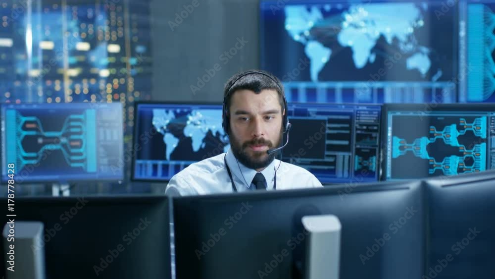Poster In the System Monitoring Room Dispatcher Speaks into Headset, Observers Proper Functioning of the Facility. He's Surrounded by Screen Showing Technical Data. 