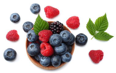 mix of blueberries, blackberries, raspberries in wooden bowl isolated on white background. top view
