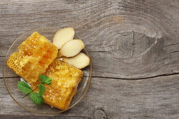healthy background. honey, honeycomb, lemon, ginger on old wooden table. Top view with copy space