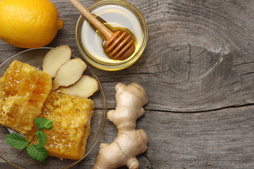 healthy background. honey, honeycomb, lemon, ginger on old wooden table. Top view with copy space