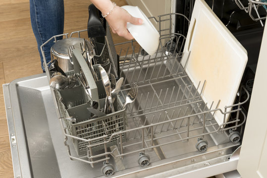 Woman's Hand Placing a Bowl in Dishwasher Rack