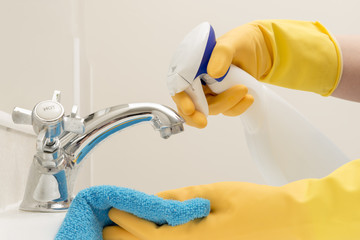 Hands in Gloves Spraying Liquid Detergent on Rag