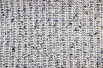 Gray knitted background. Knitted texture. A sample of knitting. Knitting Pattern.