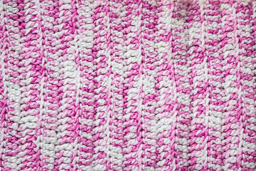Pink knitted background. Knitted texture. A sample of knitting. Knitting Pattern.