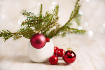 Christmas decoration with fir tree and red bolls on sparkling light background. selective focus 